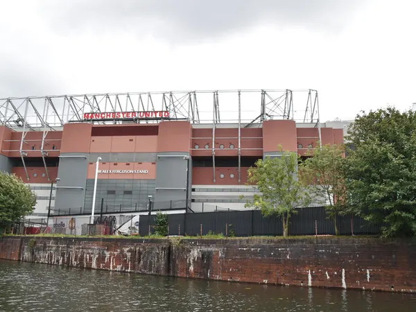 Old Trafford football stadium viewed across the Bridgewater Canal on the edge of Trafford Park