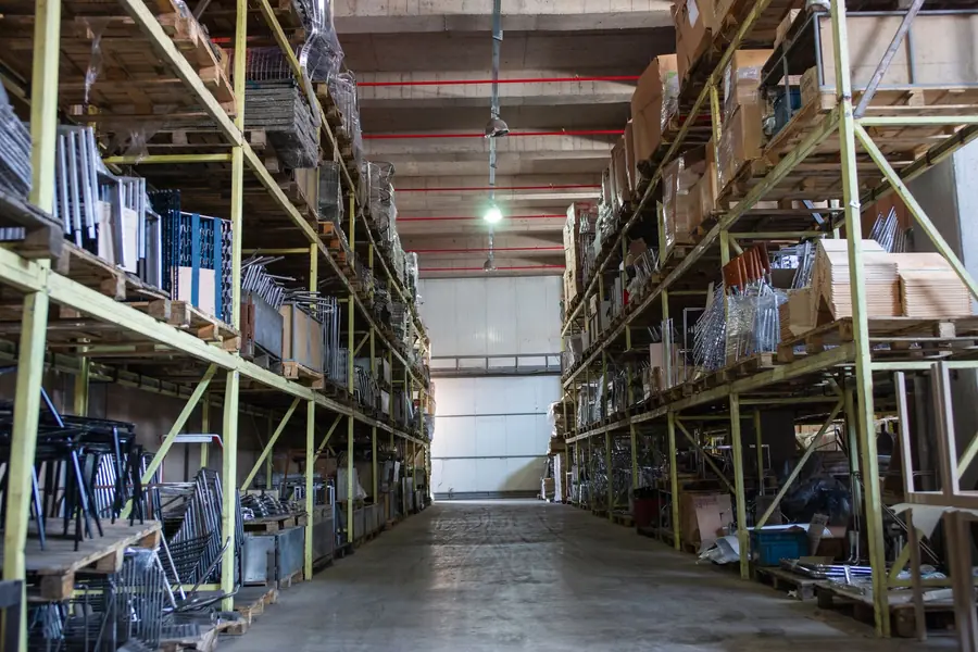 Quiet warehouse interior with racking and stock but no activity, a site with little evening power demand