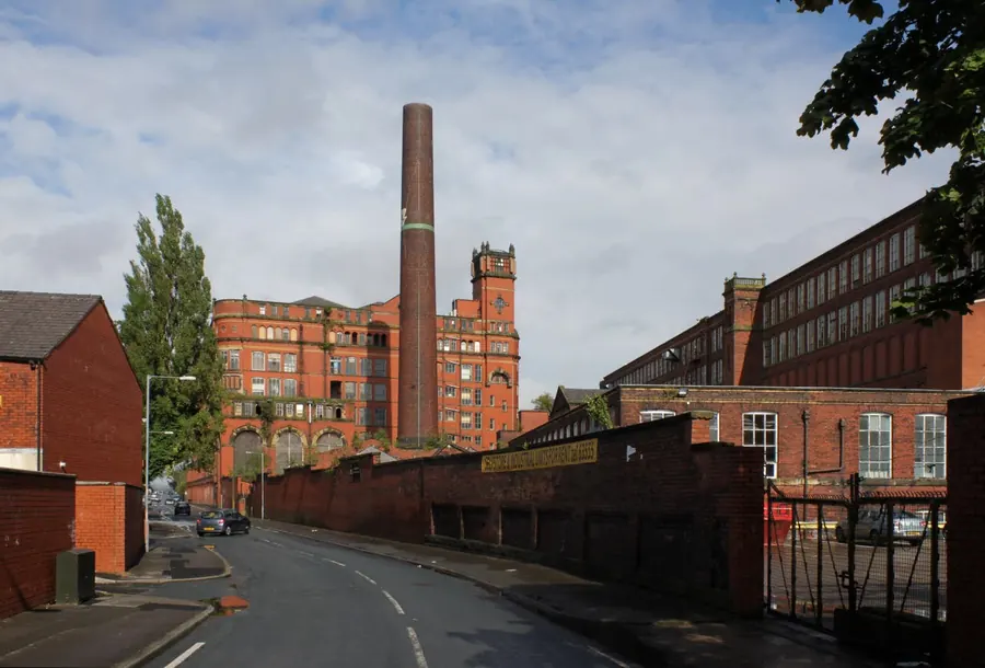 Swan Lane Mills and chimney rising above an industrial street in Daubhill, Bolton